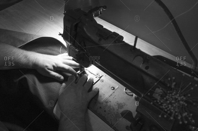 Craftsman using a sewing machine to create leather ware