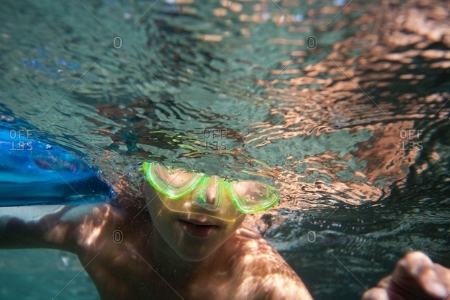 Underwater view of boy wearing goggles swimming underwater