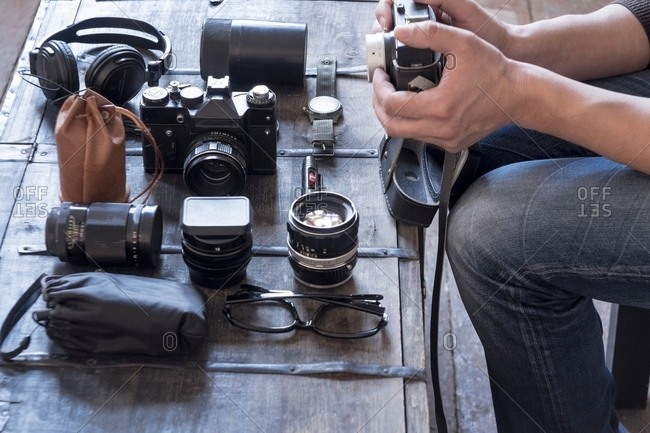 Photographer preparing camera and accessories at desk
