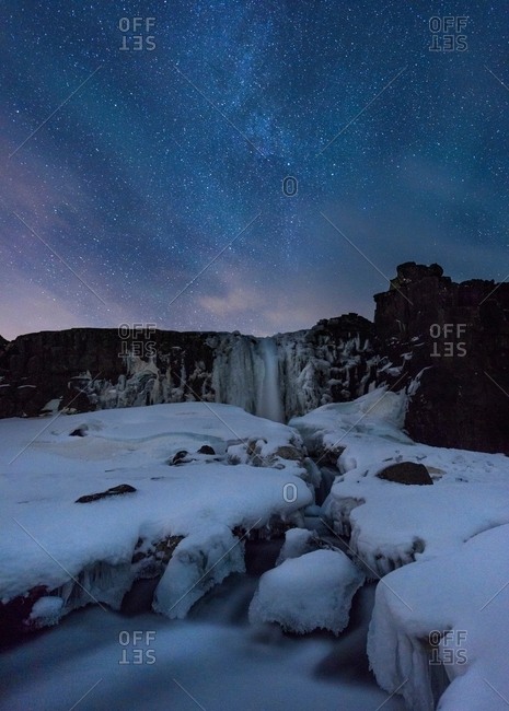 Icy snow covered landscape underneath starry night sky, Thingvellir, Iceland