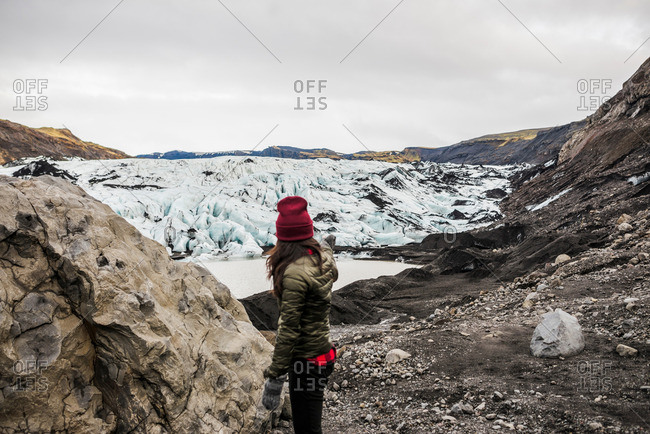Female tourist pointing at glacier at Solheimajokull, Iceland