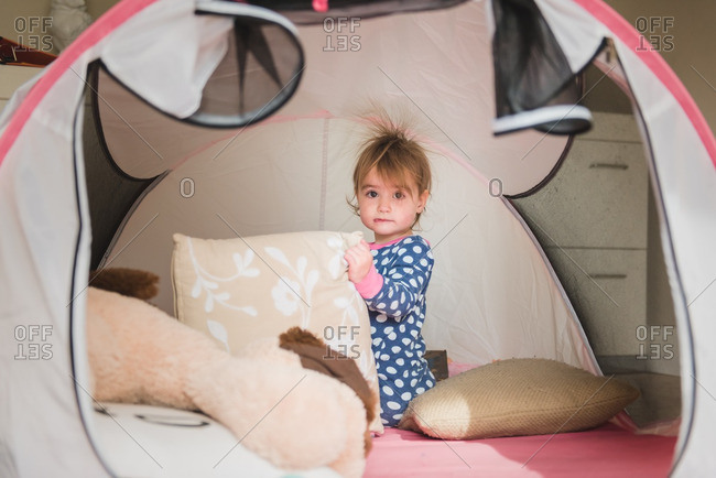 Toddler girl in play tent with hair standing up from static electricity