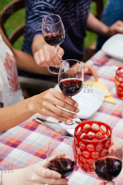 People raising glasses of red wine