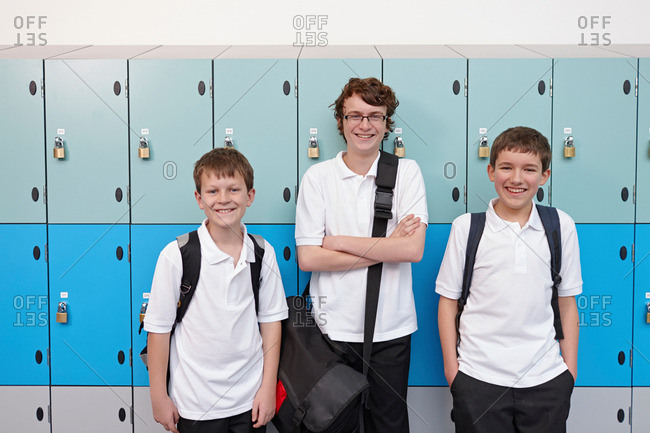 Portrait of three boys next to school lockers