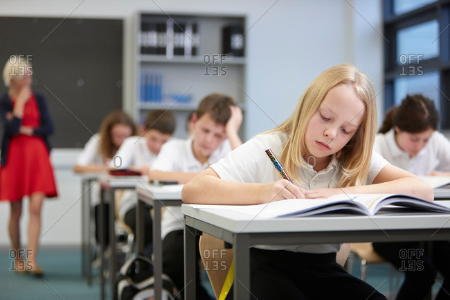 Female teacher watching class doing educational exam