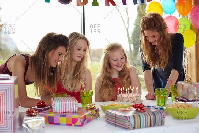Teenage girl sharing birthday cake with friends