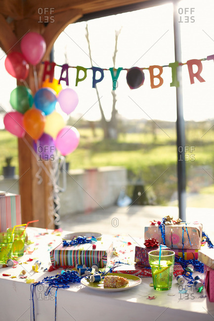 Table laid for birthday party with balloons and streamers