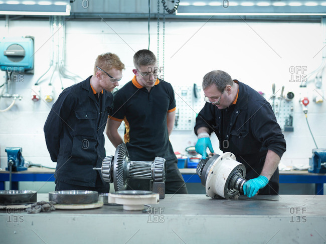 Apprentices learning from an engineer in engineering factory