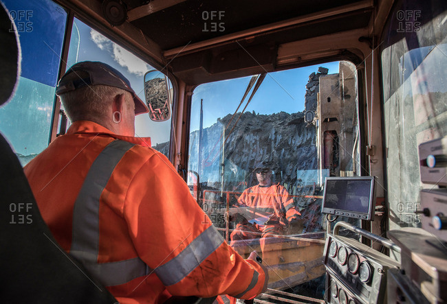 Excavator driver in digger cab at surface coal mine