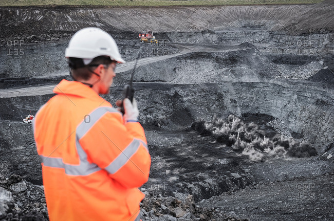 Miner overseeing blasting explosion in surface coal mine