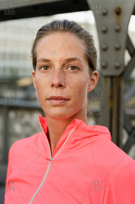Portrait of confident young female runner on bridge