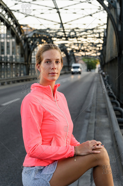 Portrait of young female runner on bridge