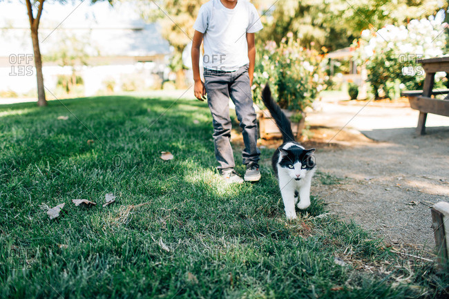 Boy walking outside with a cat