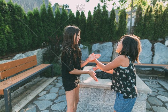 Two young sisters playing clapping game