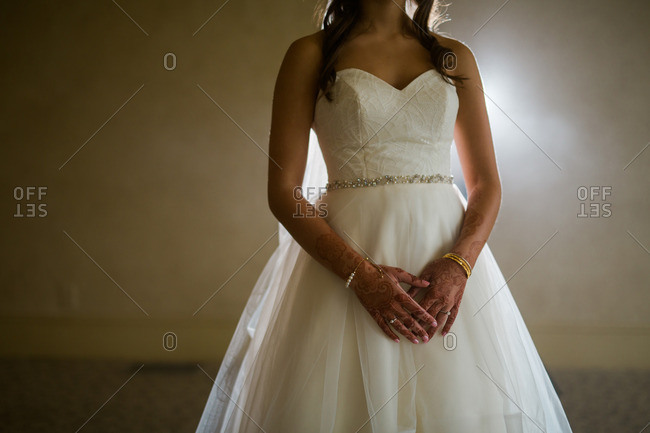 Bride with henna tattoos wearing a wedding dress with a sweetheart neckline