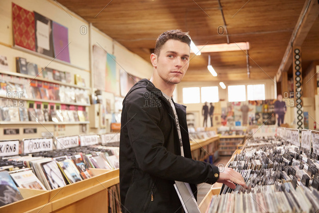 Young man browsing vinyl records in music store