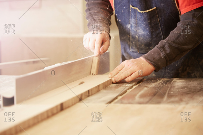 Close up of cabinet maker using table saw in workshop