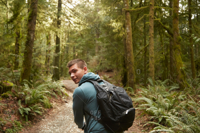 Young man in forest wearing backpack
