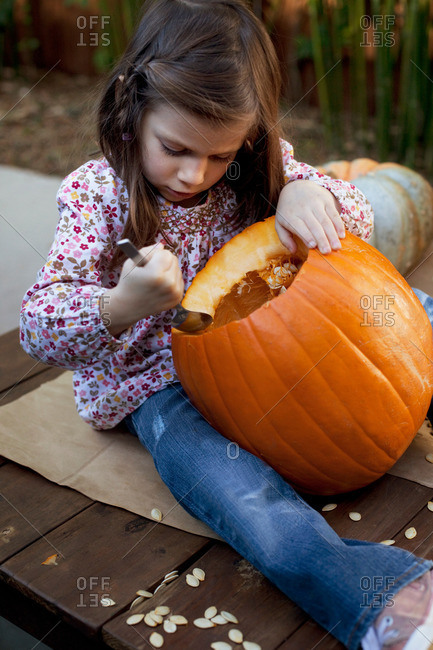 Girl carving a Jack O\'Lantern for Halloween
