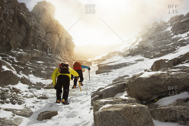 Low angle view of men hiking on snow covered Mount Whitney