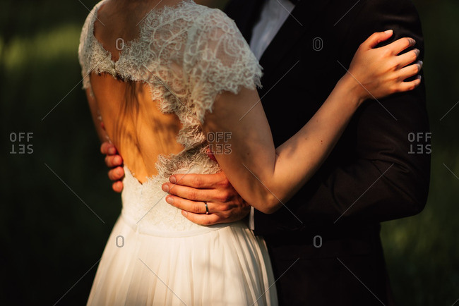 Close up of groom standing with his hands on his brides waist
