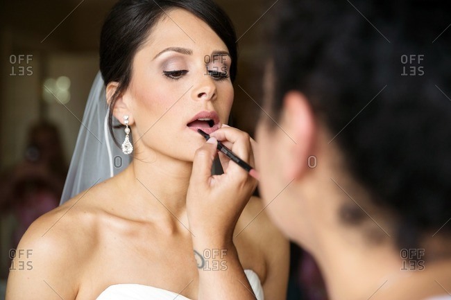 Woman putting lip liner on a bride