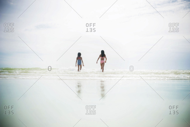 Two girls wading in the ocean