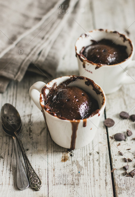 Elevated view of two chocolate cakes cooked in mugs