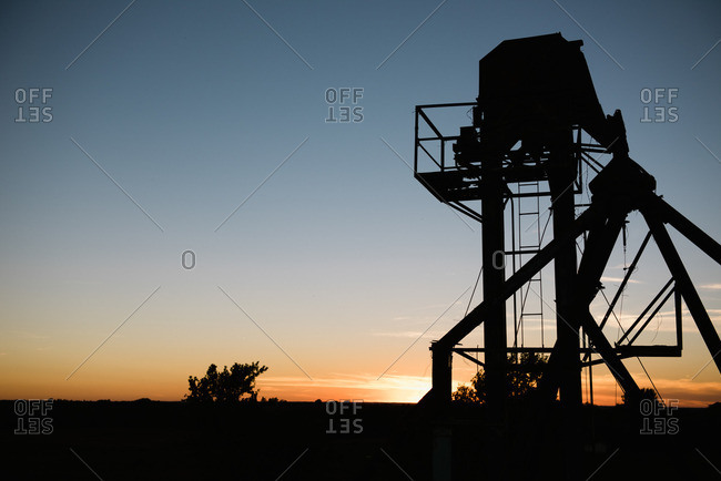 Silhouetted agricultural structure at sunset