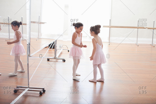 Two child ballerinas chatting in ballet school