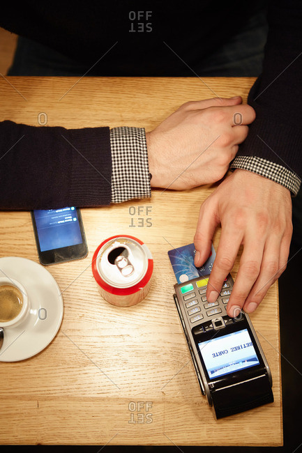 Customer in restaurant entering pin number into credit card reader