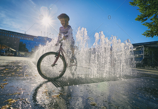 Boy on bike in city fountain