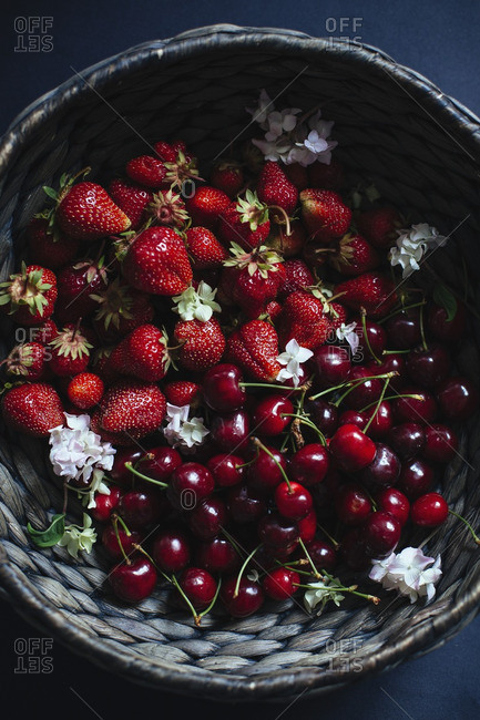 Cherries, strawberries and flowers in a basket