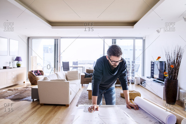 Man looking at architectural plans at home