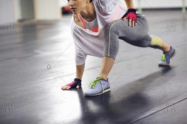 Low section of female athlete exercising in health club