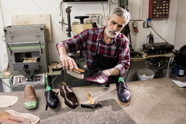 High angle view of cobbler polishing a shoe in his workshop