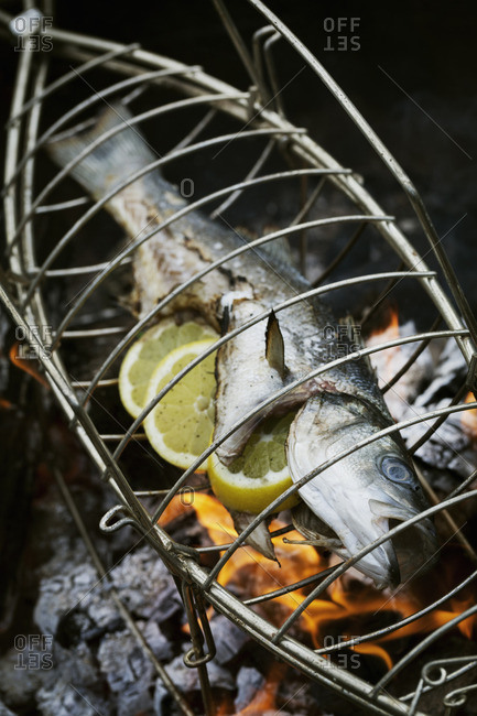 Fish in a fish grill basket over a barbecue