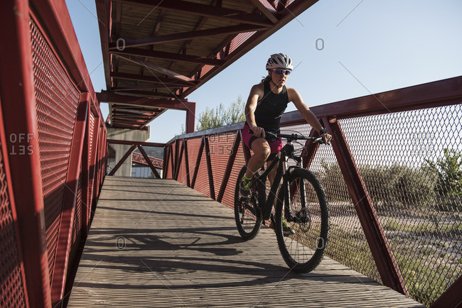 Athlete riding bicycle on a bridge