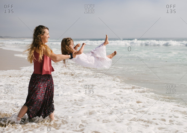 Mother pretending to throw daughter into the water