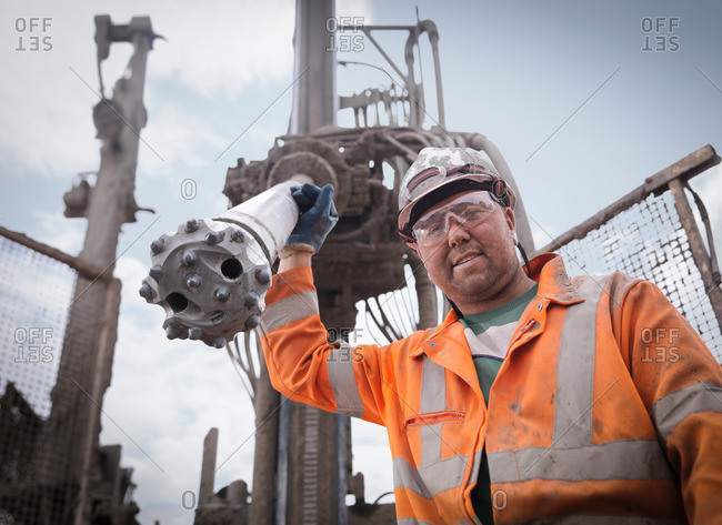 Portrait of drilling rig worker in hard hat and work wear