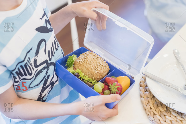 Boy packing lunch box with healthy food