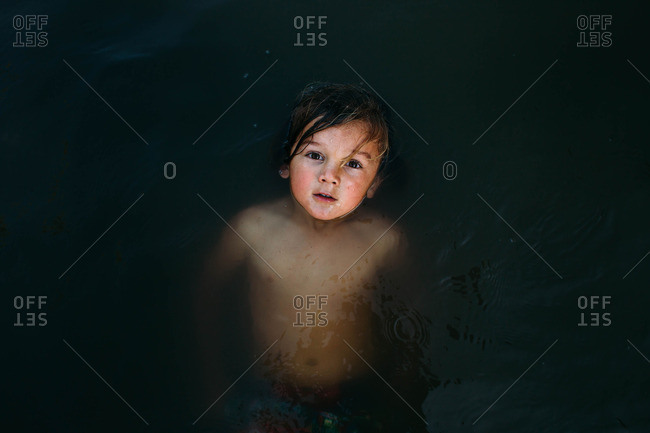 Overhead view of child floating in water