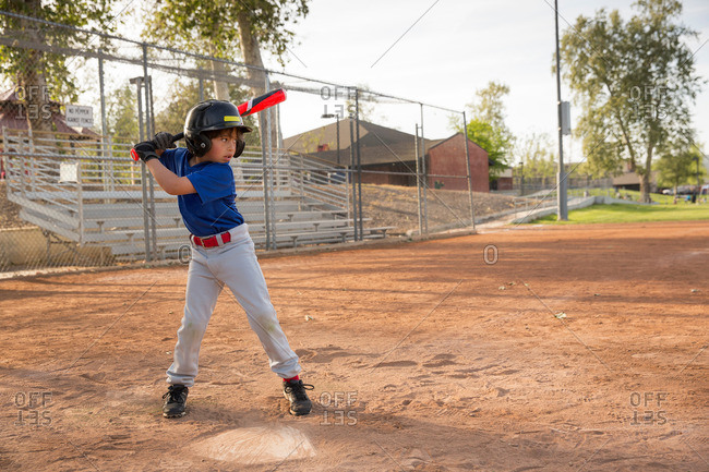 Boy batting at practice on baseball field