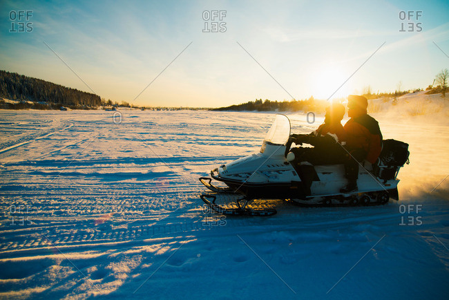 People on snowmobile on snow covered landscape