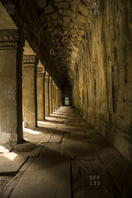Sunlight streaming between columns in an ancient temple hallway in Angkor Wat