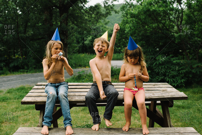 Brother and sister sitting on a picnic table at a birthday party