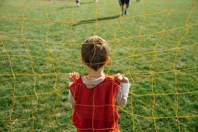 Boy standing in a soccer goal during a soccer match