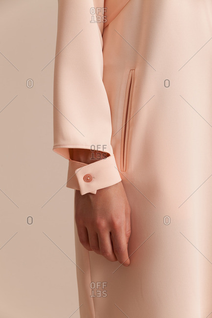 Arm of a woman wearing an elegant long-sleeve pink dress
