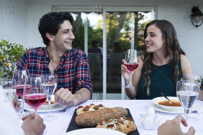 Man and woman having fun and drinking lambrusco wine during a summer dinner