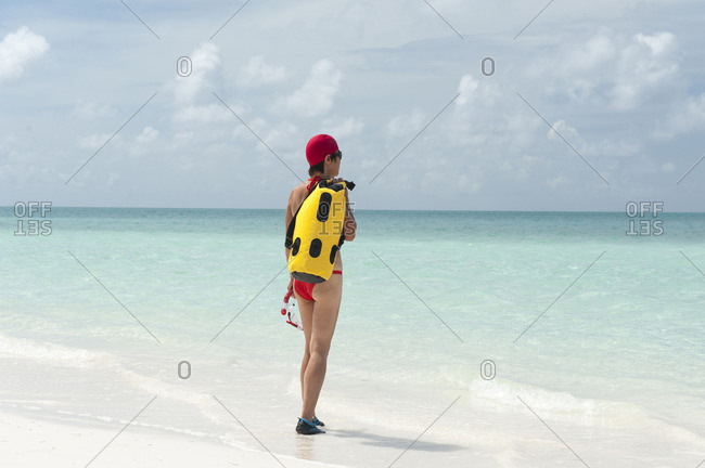 Woman with snorkeling gear entering water